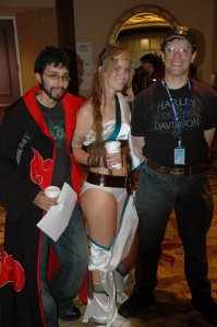 Scififantasyanimeman in street clothes posing with some cosplayers.